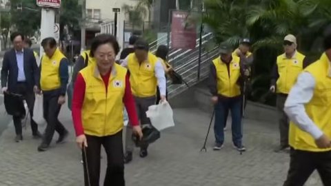 Com coletes amarelos, participantes recolhem lixo e fortalecem laços comunitários, promovendo segurança e estética no bairro - Imagem: Reprodução/TV Globo