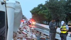 Motoristas aproveitaram o tombamento de caminhão para saquear parte da carga - Imagem: Reprodução / SBT