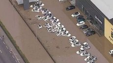 Imagens da concessionária submersa circulam nas redes sociais, evidenciando a gravidade da situação em Guarulhos. - Imagem: Reprodução | TV Globo