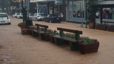 Rua da região central de Serra Negra (SP) alagada após córrego transbordar depois do temporal. - Imagem: Reprodução/Redes Sociais.