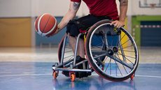 Atleta cadeirante jogando basquete em ginásio - Imagem: Freepik