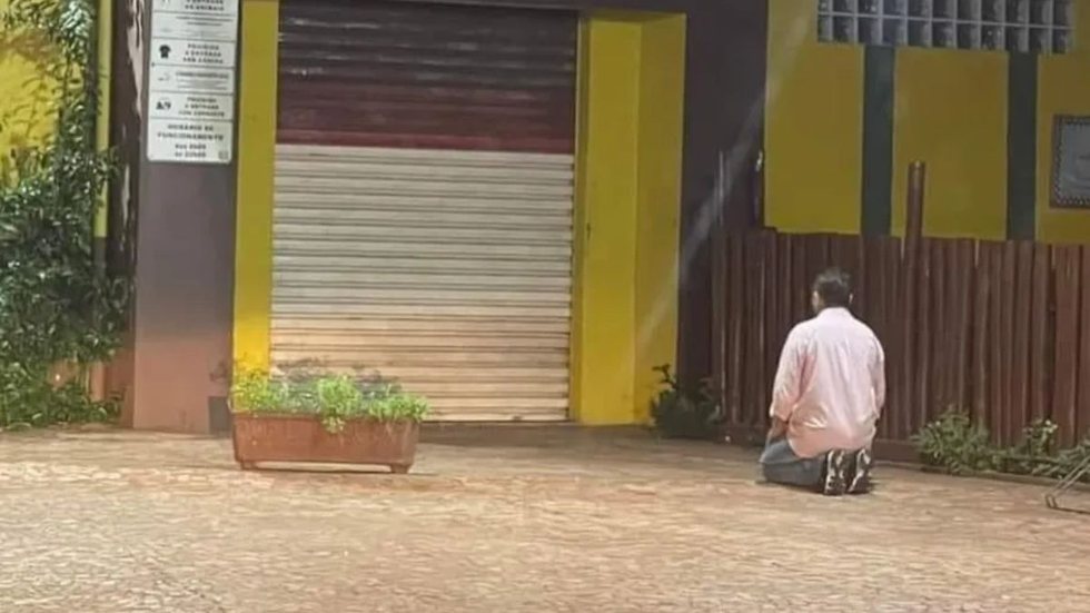 Uma foto de um empresário em frente à sua padaria em Votuporanga (SP) mostra o homem, antes de abrir o comércio, fazendo uma oração. - Imagem: reprodução I G1