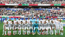 Seleção iraniana perfilada para partida contra a Nova Zelândia, válida pelo grupo G da Copa do Mundo de 2026 - Imagem: Reprodução/Agência de Notícias Xinhua