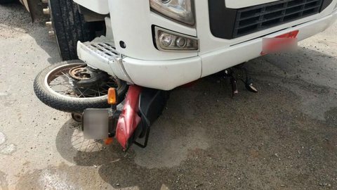 Moto fica presa debaixo de caminhão após tentativa de ultrapassagem
