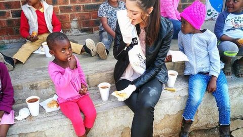 Miss sul-africana gera polêmica e acusações de racismo por usar luvas em visita a orfanato