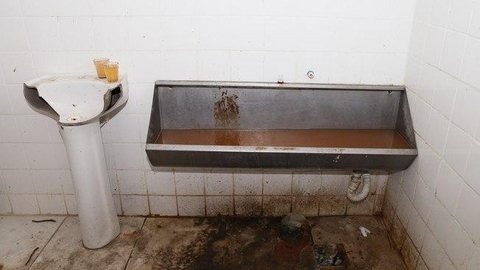 Homem obrigado a lamber mictório de banheiro público processa polícia e cidade