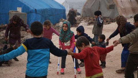Menina síria brinca com novas próteses em campo de refugiados após usar pernas de canos e latas