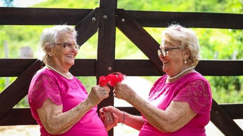 Gêmeas de 98 anos celebram a vida em ensaio fotográfico e revelam que a felicidade está nas coisas simples: ‘banho de balde e crochê’