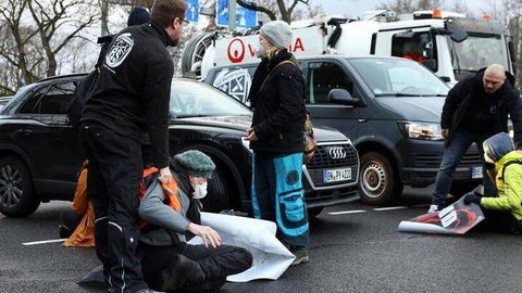 Ativistas climáticos protestam colados ao asfalto em Berlim