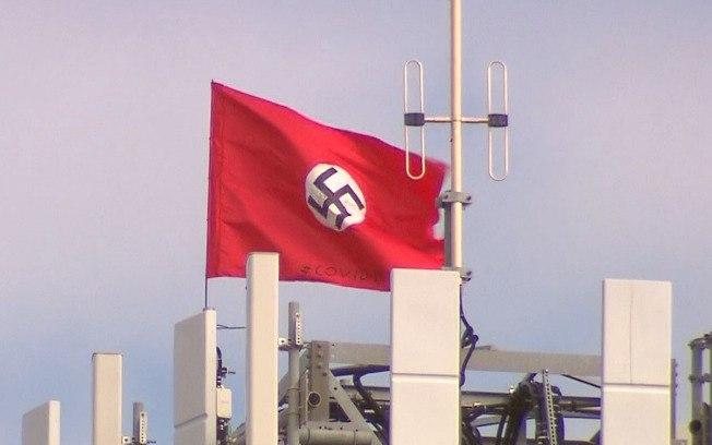 Bandeiras estendidas em torre na Austrália relacionam Covid-19, nazismo e China