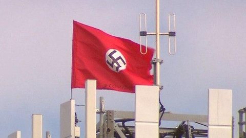 Bandeiras estendidas em torre na Austrália relacionam Covid-19, nazismo e China