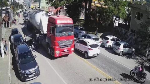Imagem Motorista abre porta de carro em motociclista e o joga para debaixo de caminhão