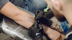 Homem fazendo uma tatuagem - Imagem: Reprodução / Freepik