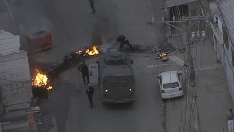 A resposta do tráfico incluiu a invasão de ônibus e bloqueios, levando a uma operação policial em resposta a roubos na área - Imagem: Reprodução/TV Globo