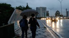 Pessoas se protegem da chuva em São Paulo - Imagem: Reprodução / Agência Brasil / Fernando Frazão