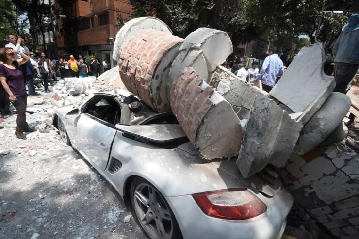 Carro é atingido por escombros de prédio após terremoto atingir a Cidade do México (Foto: Alfredo Estrella / AFP)