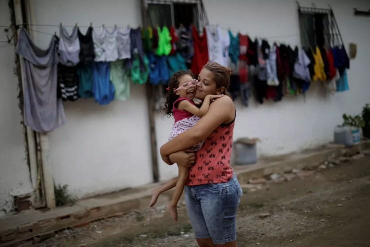 Gabriela Alves de Azevedo, 22, segura a filha de dois anos Ana Sophia, que nasceu com microcefalia, na casa delas em Olinda — Foto: Ueslei Marcelino/Reuters