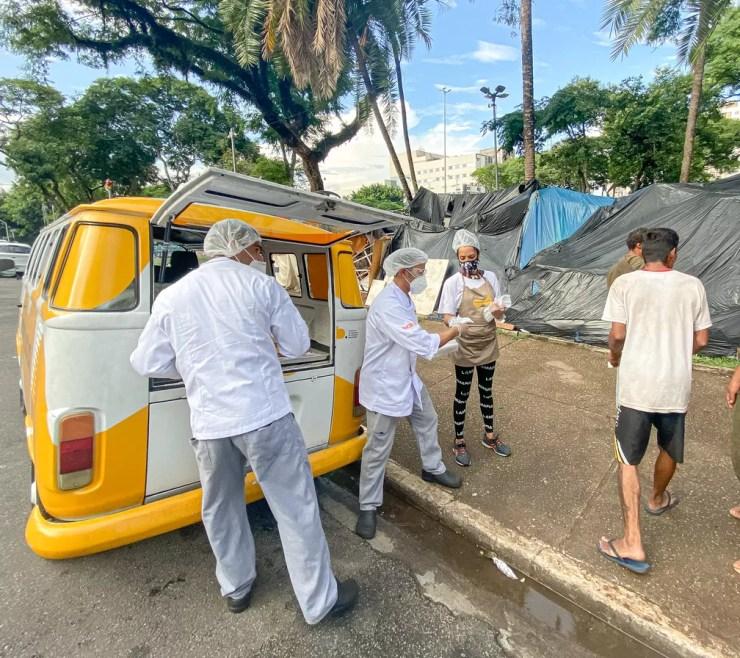 Cristóvam e William distribuem o pão que já comeram nas ruas — Foto: Celso Tavares/g1