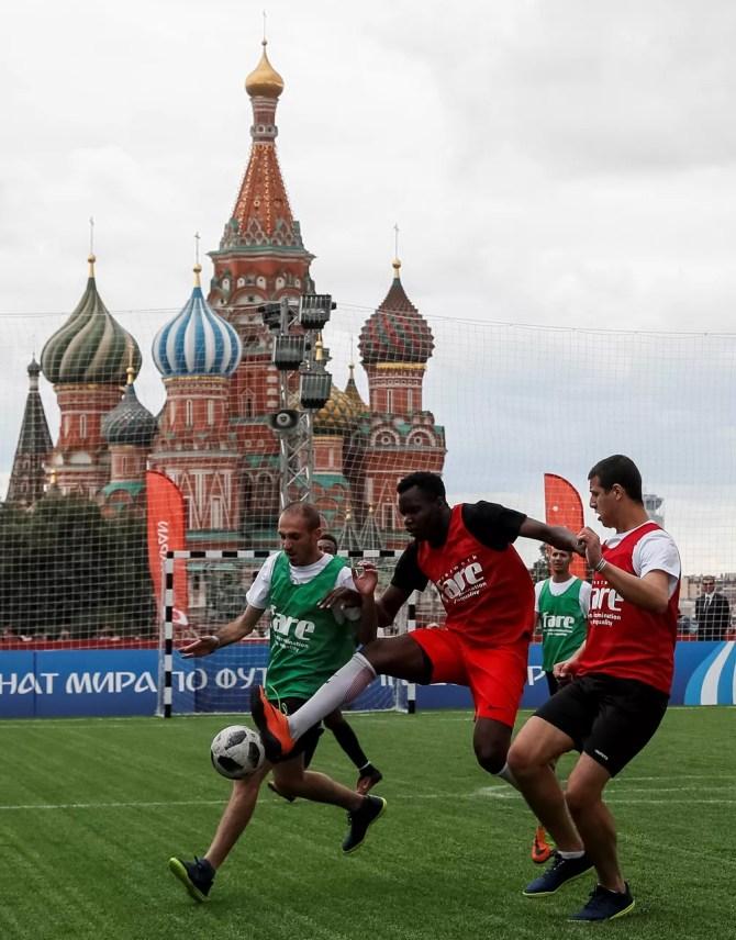 Imigrantes na Rússia jogam futebol em frente à Catedral São Basílio, na Praça Vermelha, em Moscou (Foto: Reuters/Gleb Garanich)