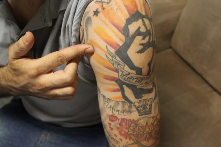 Charles mostra a tatuagem que tem no braço esquerdo, visível em uma das fotos do perfil falso (Foto: Carlos Dias/G1)