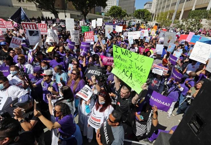 Militantes a favor do Obamacare protestam contraTrump por tentar acabar com o programa em Los Angeles, em março de 2017 — Foto: Reed Saxon/AP
