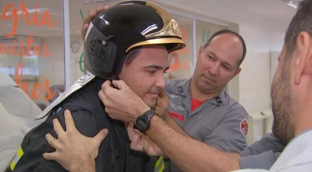 Luís coloca o capacete especial dos bombeiros (Foto: Reprodução/TV TEM)