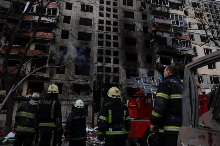 Bombeiros em frente a um prédio atacado em Kiev, em 14 de março de 2022 — Foto: Thomas Peter/Reuters