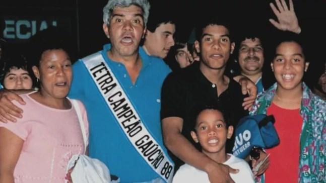 A família Assis, com João, de faixa do Grêmio, e o pequeno Ronaldo, abraçado a Assis — Foto: Reprodução