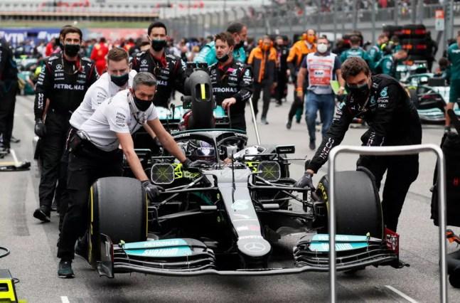 Mecânicos da Mercedes conduzem carro de Lewis Hamilton até o grid do GP da Rússia — Foto: Yuri Kochetkov - Pool/Getty Images