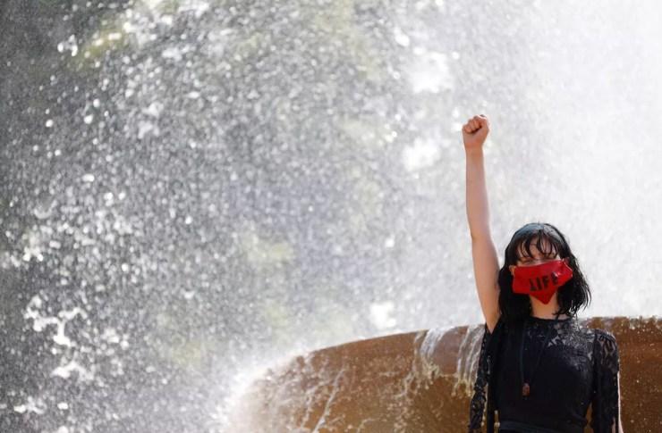 9 de agosto - Mulher gesticula em uma fonte em Trafalgar Square após corante vermelho ser derramado na água, durante protesto contra o impacto do coronavírus (Covid-19) nas comunidades indígenas do Brasil, em Londres — Foto: John Sibley/Reuters