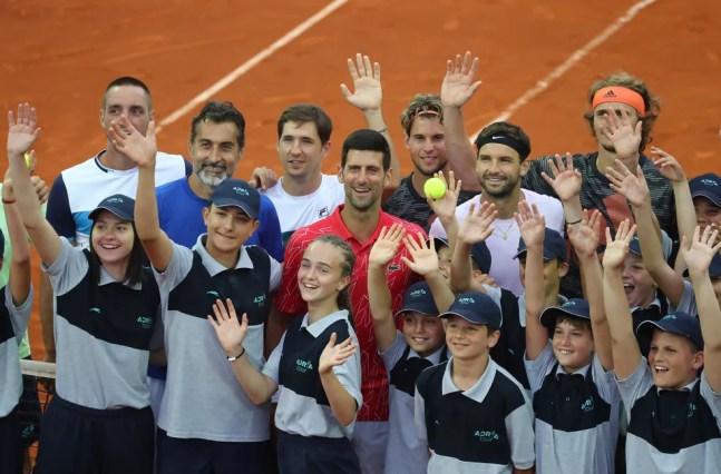 Com Novak Djokovic no centro, tenistas se aglomeram com catadores de bolinha no Adria Tour, em Belgrado — Foto: Reuters
