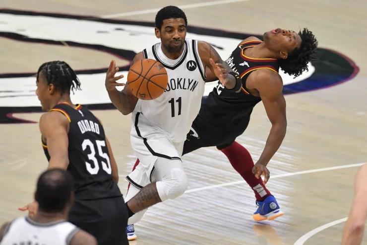 Kyrie Irving passa por Collin Sexton, cestinha da noite na partida entre Cleveland Cavaliers e Brooklyn Nets — Foto: Getty Images