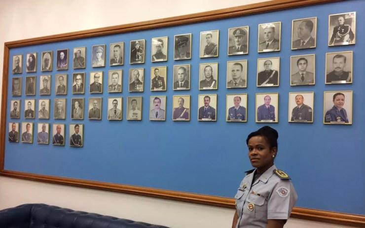 Helena Reis posa ao lado do quadro dos demais secretários da Casa Militar, em seu gabinete no Palácio dos Bandeirantes  (Foto: Lívia Machado/G1)