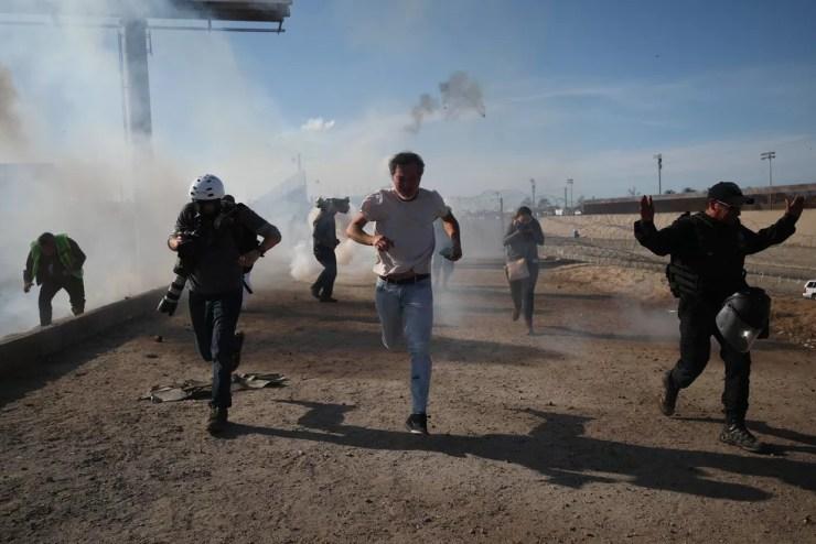 Oficiais dos EUA tentam conter imigrantes com gás lacrimogêneo — Foto: Reuters