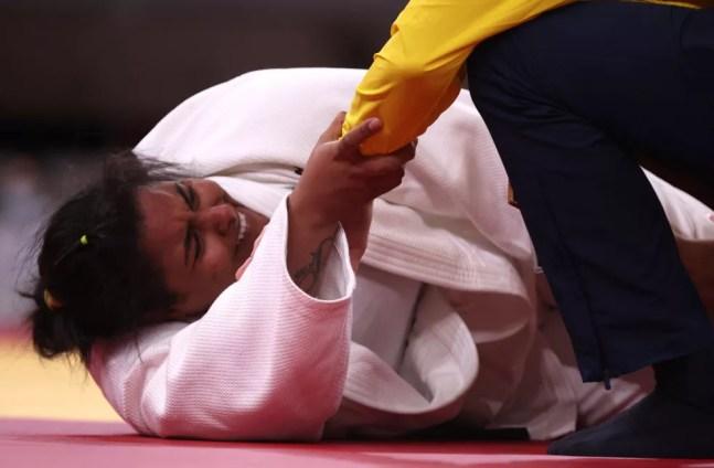 Maria Suelen Altheman segura no braço do médico da seleção brasileira após sentir lesão nas Olimpíadas de Tóquio — Foto: Chris Graythen/Getty Images