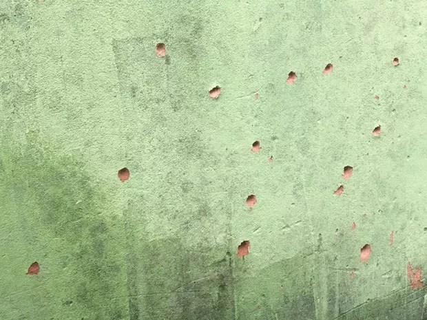 Marcas de bolas de gude na parede da casa do suspeito (Foto: André Modesto/TV TEM)