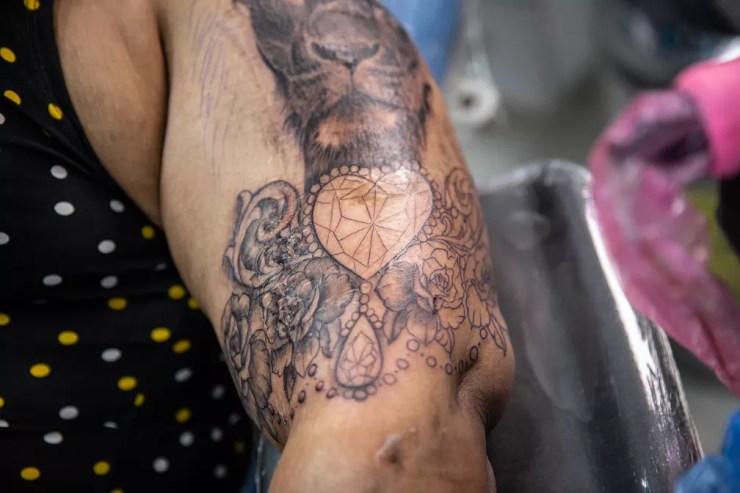 Durante o processo: tatuagem que Joseane escolheu combina as figuras de um leão, flores e diamantes, o maior deles em formato de coração — Foto: Fábio Tito/g1