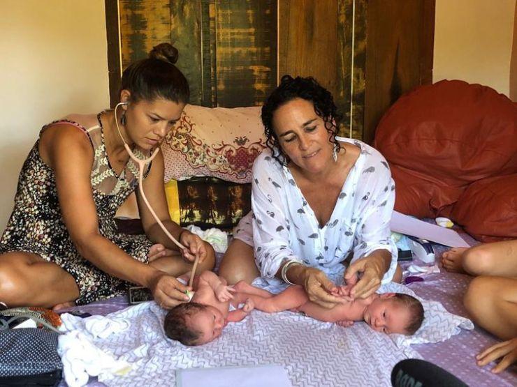 As parteiras Mayra Calvete (esquerda) e Naoli Vinaver (direita) fazem checagem em bebês após o parto