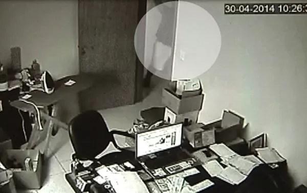 Câmera mostra o momento em que suspeito, ao fundo, atinge empresário com marreta (Foto: Reprodução/TV TEM)