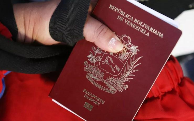 Venezuelana exibe passaporte em aeroporto em Lima, no Peru, antes de embarcar com destino à Venezuela, em imagem de arquivo — Foto: Teo Bizca/AFP
