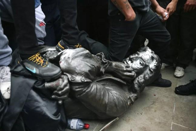 7 de junho - Manifestantes derrubam  estátua do traficante de escravos Edward Colston, em Bristol, na Inglaterra — Foto: Ben Birchall/PA via AP