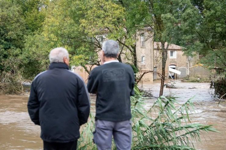 Moradores observam enchente na cidade de Villegailhenc, no sul da França, nesta segunda-feira (15)  — Foto: Fred Lancelot/PA