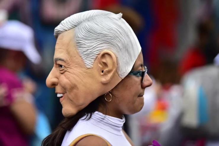 Apoiadora de López Obrador usa máscara do político em evento de campanha na Cidade do México — Foto: Pedro Pardo/AFP