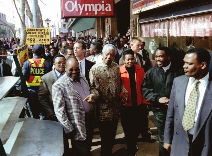 Jacob Zuma (de paletó xadrez) caminha com Nelson Mandela no centro de Joanesburgo em julho de 1997 — Foto: Juda Ngwenya/Reuters