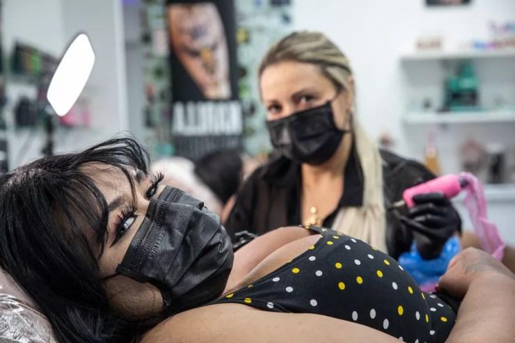 Joseane olha para a câmera durante sessão com a tatuadora Karlla Mendes para cobrir uma cicatriz no braço, em um estúdio na Zona Norte de São Paulo — Foto: Fábio Tito/g1