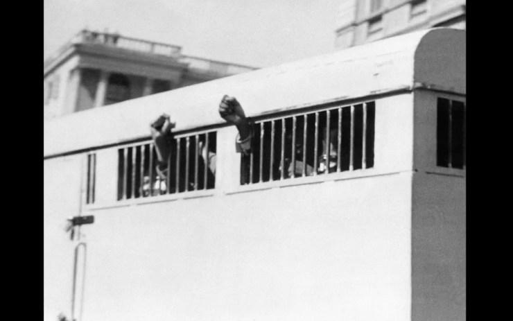 Junho de 1964 - Oito homens, entre eles o líder anti-apartheid e então membro do Congresso Nacional Africano Nelson Mandela, são levados do Palácio da Justiça em Pretória após condenação à prisão perpétua. Eles aparecem erguendo os punhos em sinal de luta — Foto: AFP/Arquivo