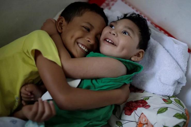 Daniel Vieira, que tem dois anos e nasceu com microcefalia, é abraçado pelo irmão na casa em que moram em Olinda — Foto: Ueslei Marcelino/Reuters