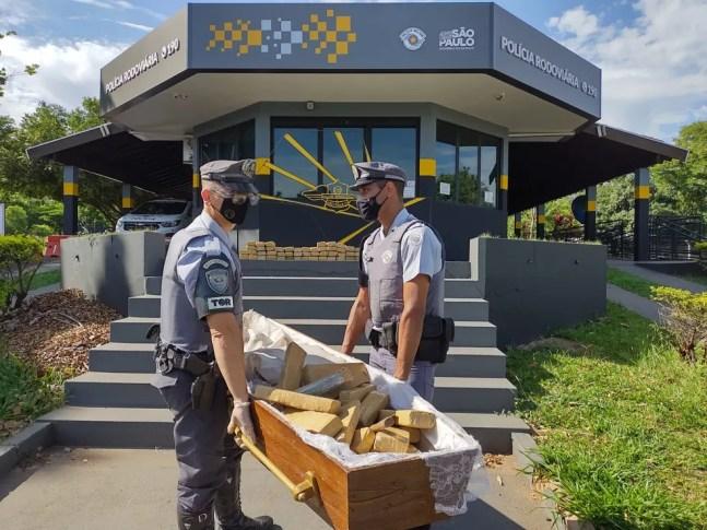 Policiais carregam caixão com drogas apreendidas no interior de SP — Foto: Divulgação