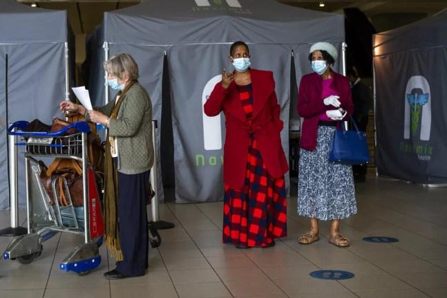 Passageiros perto de local de testes para Covid-19 no aeroporto de Joanesburgo — Foto: Jerome Delay/AP