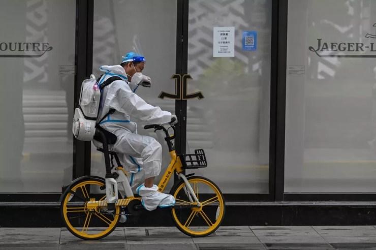 Agente de limpeza em bicicleta pelas ruas de Xangai, em 31 de maio de 2022. A flexibilização ainda não é total na cidade. — Foto: Hector Retamal/ AFP 